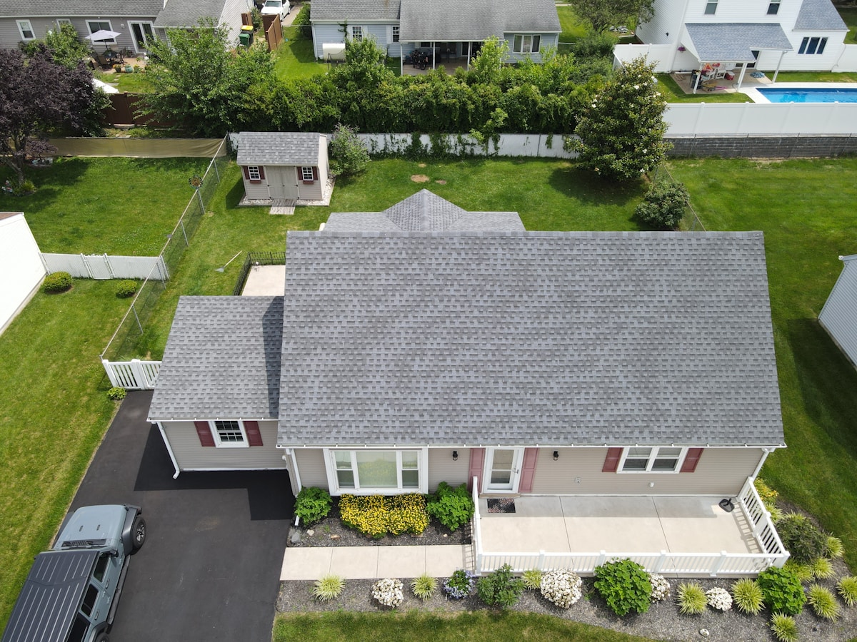 Aerial photo of a freshly installed shingle roof on a suburban home